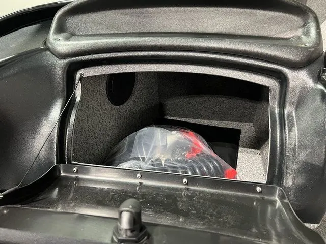 Slide: The Image of Interior view of a storage compartment with gray carpeting and a plastic bag. - 10
