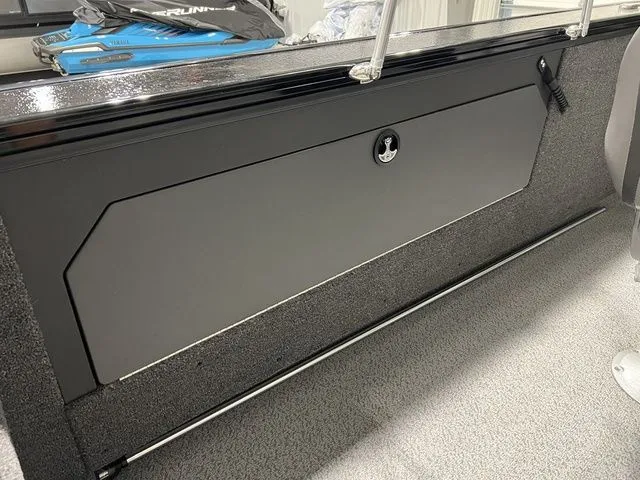 Slide: The Image of Interior view of a Lund 2075 Fisherman boat with gray storage compartment and carpeted floor. - 22