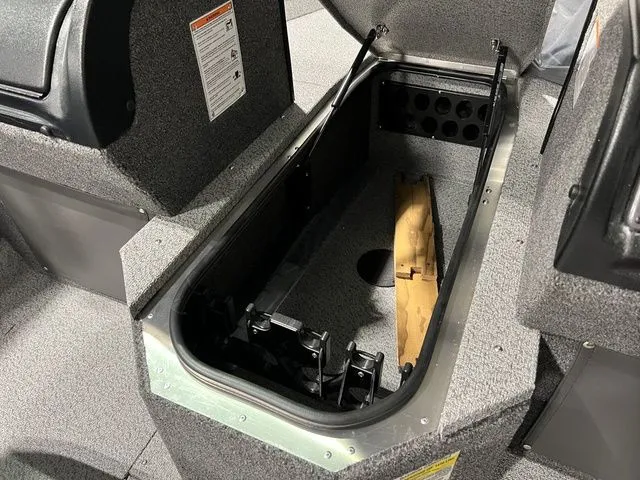 Slide: The Image of Interior view of a boat with an open storage compartment and gray carpeted flooring. - 26