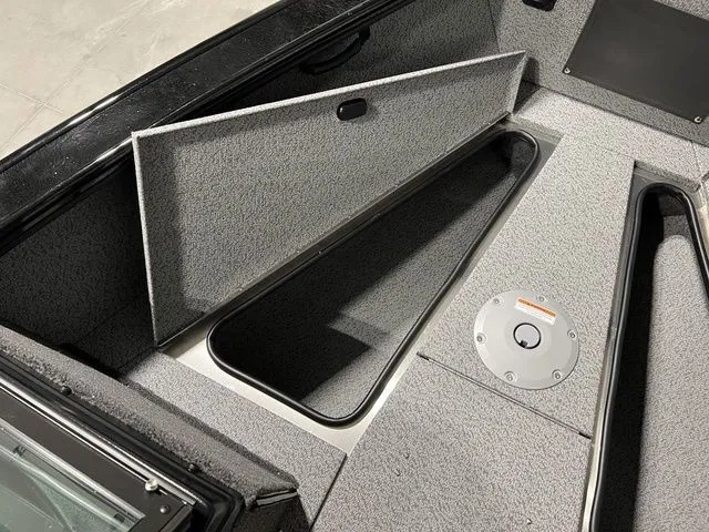 Slide: The Image of Interior view of a Lund 2075 Fisherman boat with storage compartment and gray carpeting. - 16