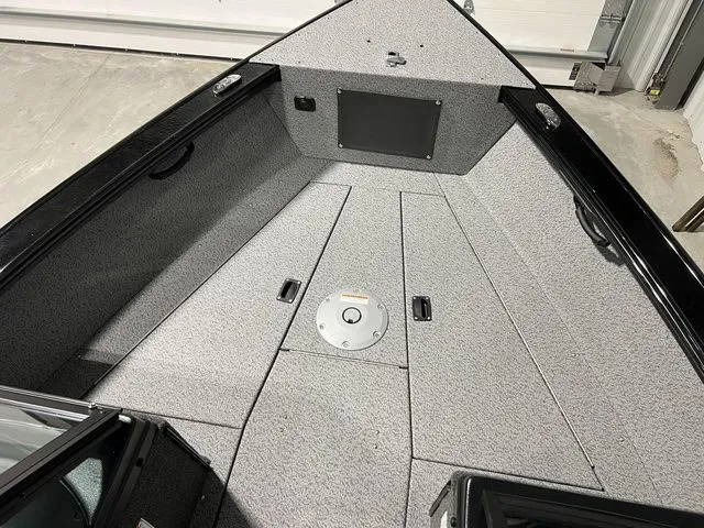 Slide: The Image of The image shows the bow of a Lund 2075 Fisherman boat with gray carpeting. - 28