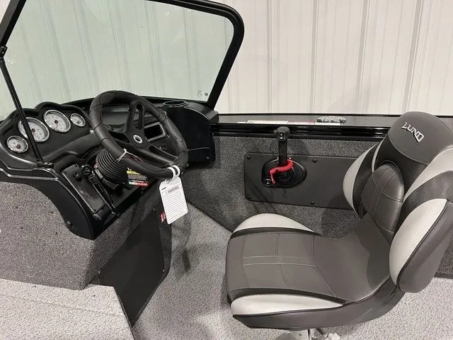 Slide: The Image of The image shows the cockpit of a Lund 2075 Fisherman boat with a steering wheel and seat. - 17