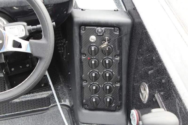 Slide: The Image of Dashboard controls of a 2027 Phoenix 818 Pro boat, featuring multiple switches and steering wheel. - 18