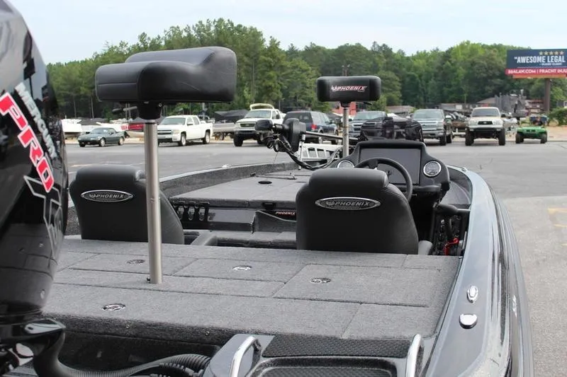 Slide: The Image of 2027 Phoenix 818 Pro boat interior with seats and dashboard, parked in a lot. - 5