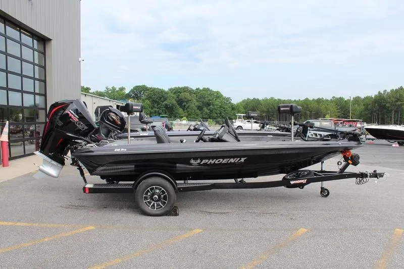 The Image of 2027 Phoenix 818 Pro boat on trailer, parked outdoors near a building. - 1