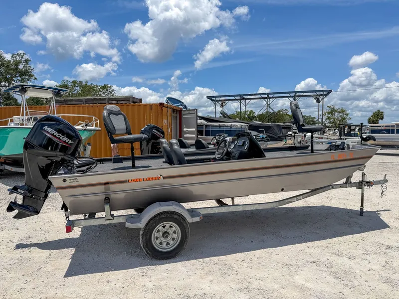 Slide: The Image of A 2022 Lowe Legacy boat on a trailer, featuring an outboard motor and multiple seats. - 9