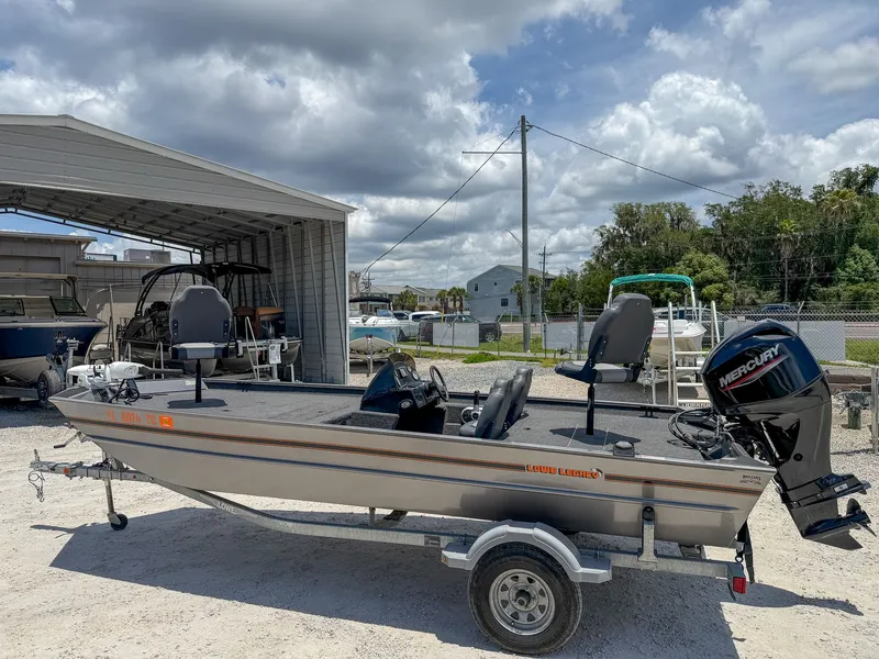 Slide: The Image of A 2022 Lowe Legacy boat on a trailer in a gravel lot. - 3