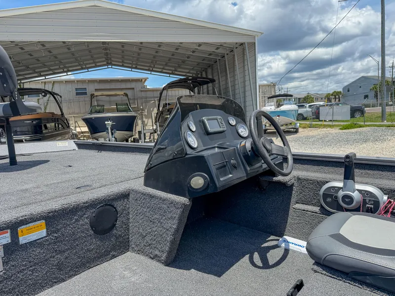 Slide: The Image of The image shows the cockpit of a 2022 Lowe Legacy boat with steering wheel and instruments. - 8