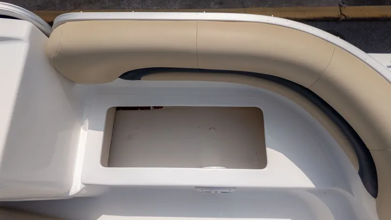 Slide: The Image of A cream-colored seat cushion on a boat with an open storage compartment below. - 12