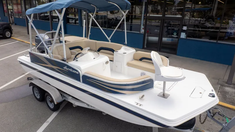 The Image of A 2015 Hurricane FD 198 boat on a trailer, featuring blue and white upholstery. - 1
