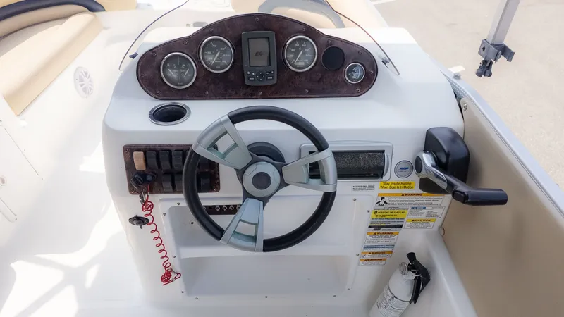 Slide: The Image of The image shows the helm of a 2015 Hurricane FD 198 boat with multiple gauges. - 20