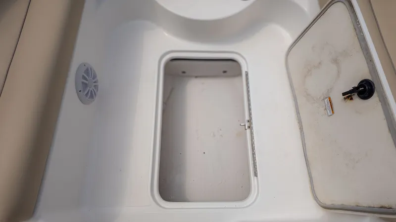 Slide: The Image of An open storage compartment on a boat with a speaker and a closed hatch nearby. - 13