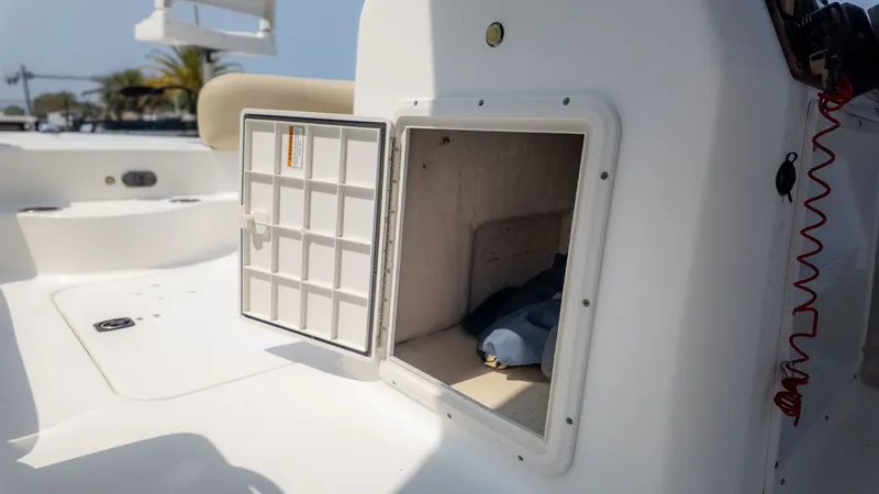 Slide: The Image of An open storage compartment on a white boat with a handrail in the background. - 17