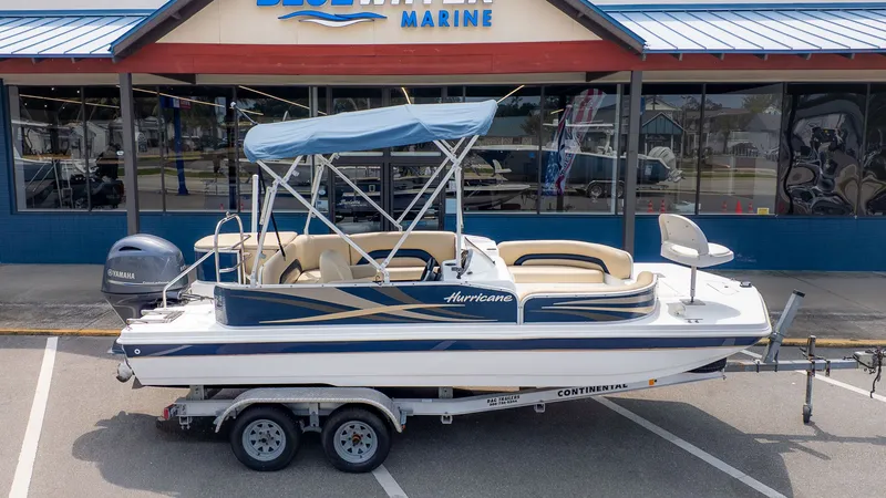 Slide: The Image of A 2015 Hurricane FD 198 boat on a trailer in front of a blue building. - 19