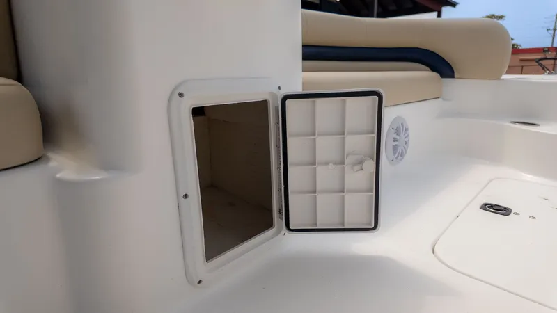 Slide: The Image of An open storage compartment on a boat with beige seating and a speaker. - 8