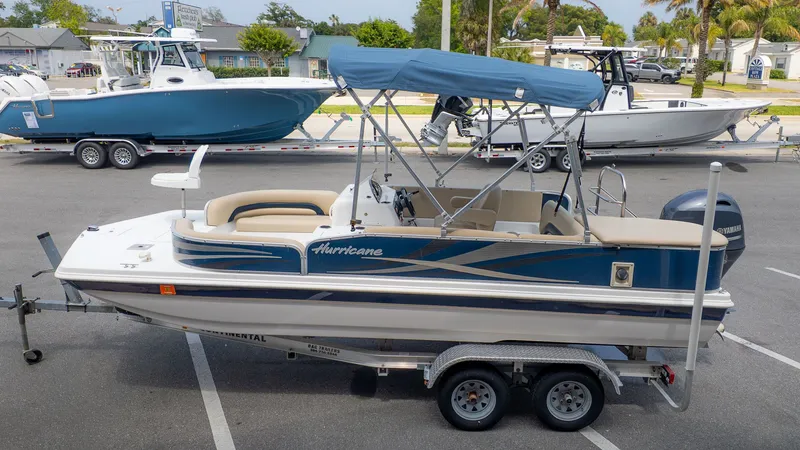 Slide: The Image of A 2015 Hurricane FD 198 boat on a trailer, featuring a blue canopy and outboard motor. - 21