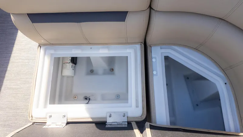 Slide: The Image of Two open storage compartments on a boat with beige upholstery. - 13