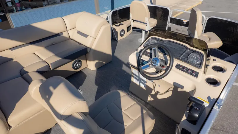 Slide: The Image of Interior of a 2022 Godfrey Sweetwater 2086 F with beige seating and a helm console. - 16