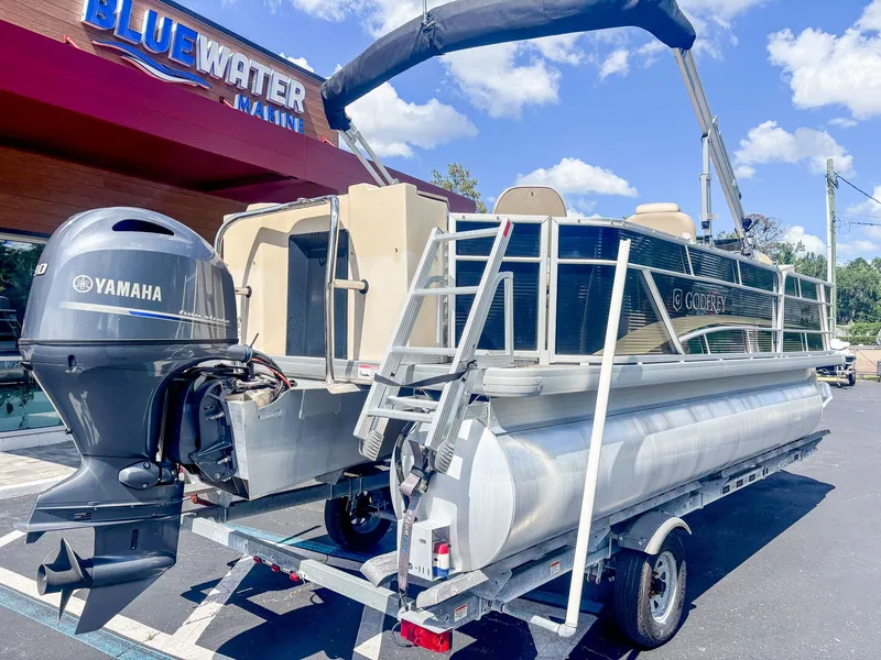 Slide: The Image of A 2022 Godfrey Sweetwater 2086 F pontoon boat on a trailer in front of a building. - 3