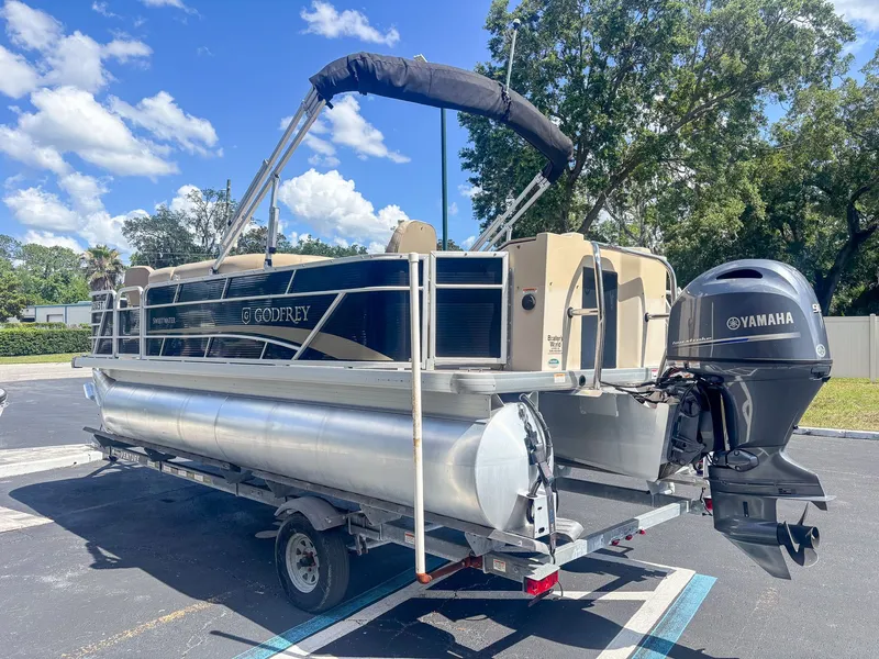 Slide: The Image of A 2022 Godfrey Sweetwater 2086 F pontoon boat on a trailer, featuring a Yamaha outboard motor. - 5