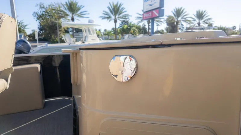 Slide: The Image of Close-up of a part of a 2022 Godfrey Sweetwater 2086 F boat with palm trees in the background. - 10