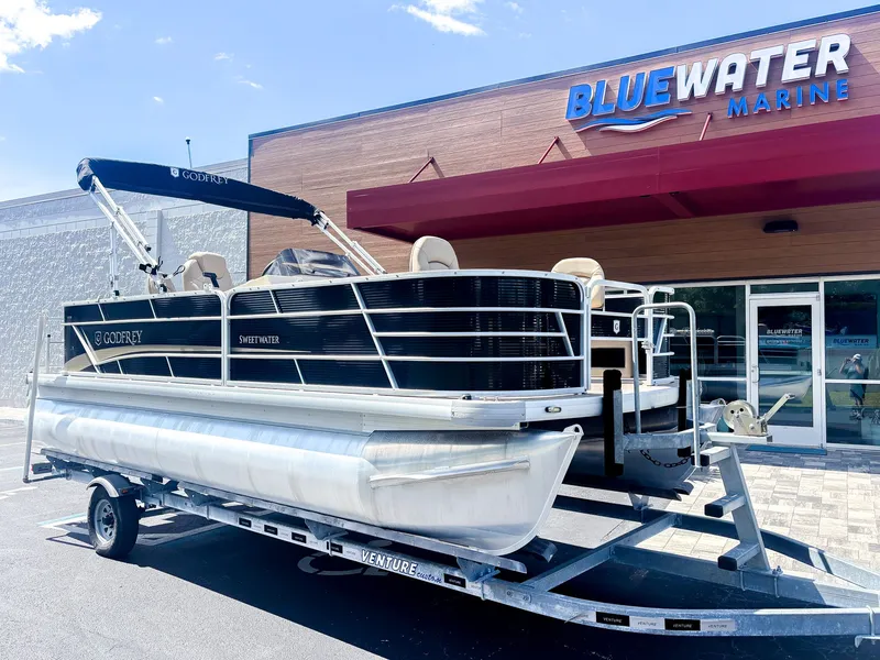Slide: The Image of A 2022 Godfrey Sweetwater 2086 F pontoon boat on a trailer in front of a building. - 25