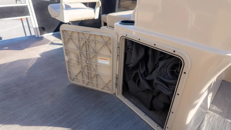 Slide: The Image of An open storage compartment on a boat with black tarps inside. - 21