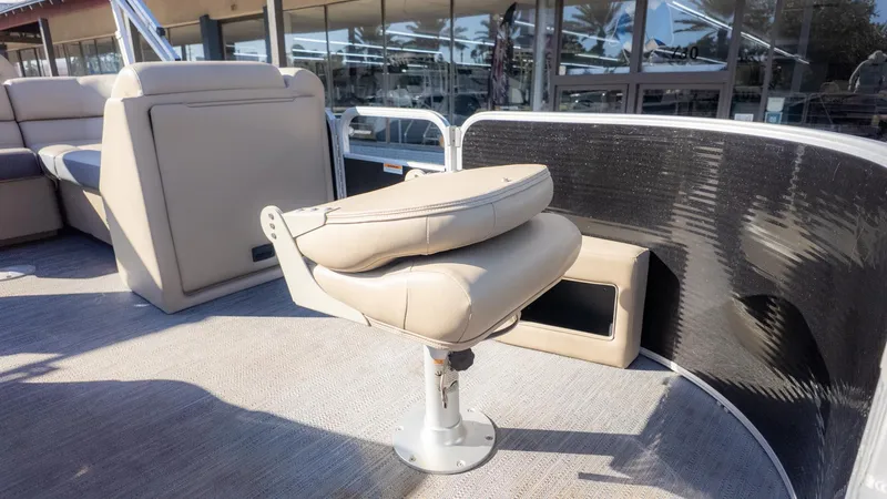 Slide: The Image of A seat on a pontoon boat with beige upholstery and a metal base, surrounded by more seating. - 18