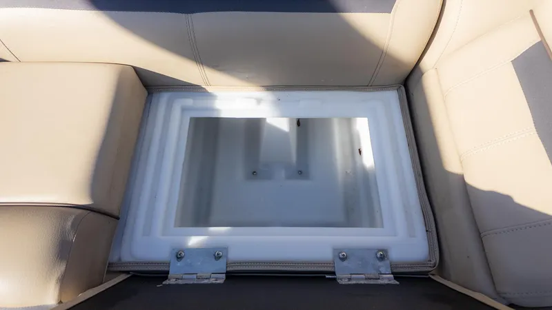 Slide: The Image of An open storage compartment on a boat with beige upholstery. - 13