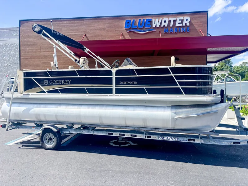 The Image of A 2022 Godfrey Sweetwater 2086 F pontoon boat on a trailer in front of a building. - 1