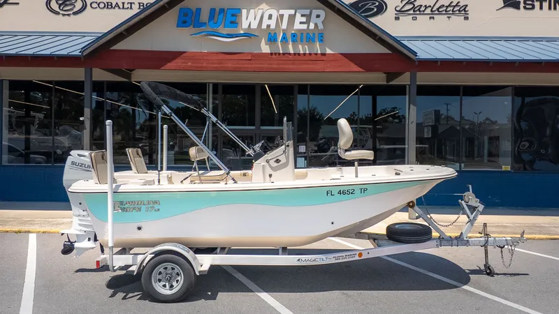 Slide: The Image of A 2023 Carolina Skiff 17 LS on a trailer in front of a marine store. - 23