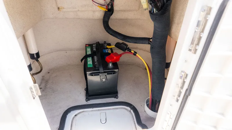Slide: The Image of Battery in a storage compartment of a 2023 Carolina Skiff 17 LS boat. - 12