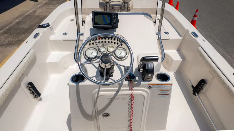 Slide: The Image of The image shows the helm of a 2023 Carolina Skiff 17 LS boat with instruments and steering wheel. - 10