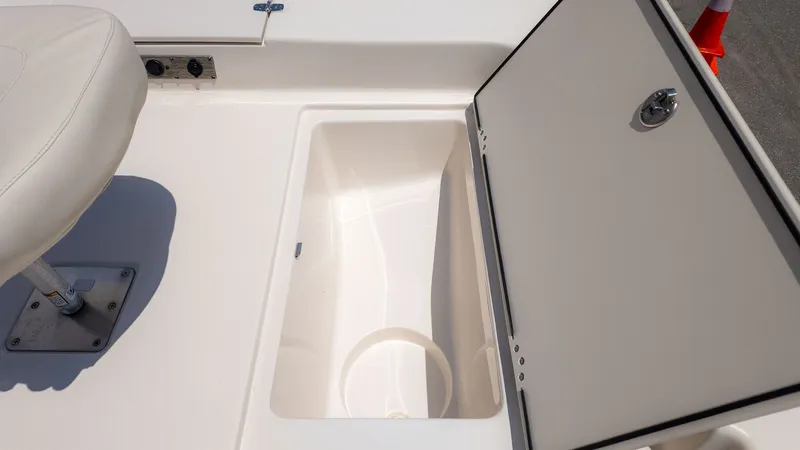 Slide: The Image of An open storage compartment on a Carolina Skiff 17 LS boat, next to a cushioned seat. - 14
