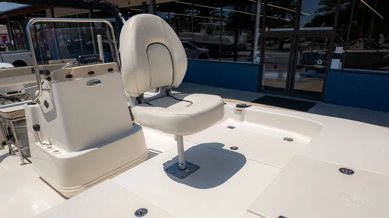 Slide: The Image of A 2023 Carolina Skiff 17 LS with a white seat and helm console on a boat deck. - 6