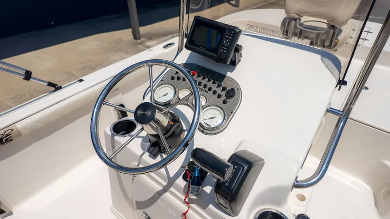 Slide: The Image of The image shows the helm of a Carolina Skiff 17 LS boat with steering wheel and instruments. - 10