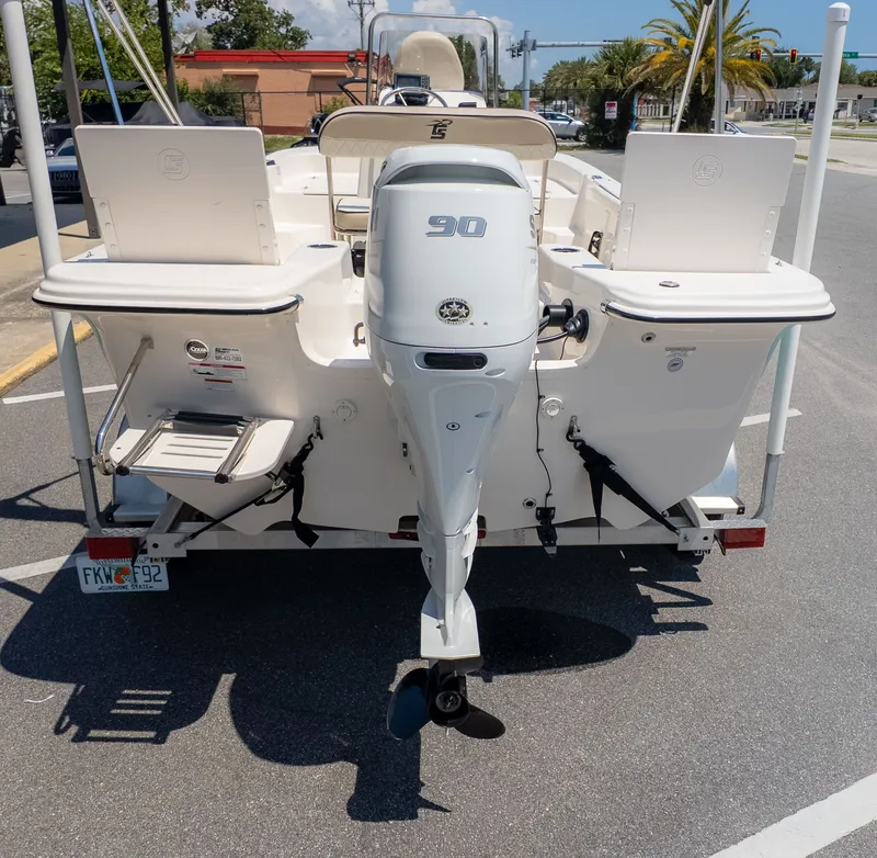 The Image of Rear view of a Carolina Skiff 17 LS with a 90 HP outboard motor, parked on a trailer. - 1
