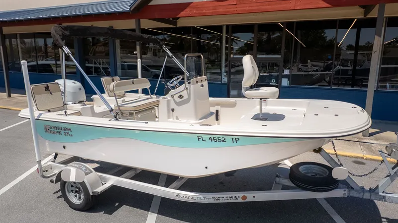Slide: The Image of A 2023 Carolina Skiff 17 LS on a trailer, parked in front of a building. - 22