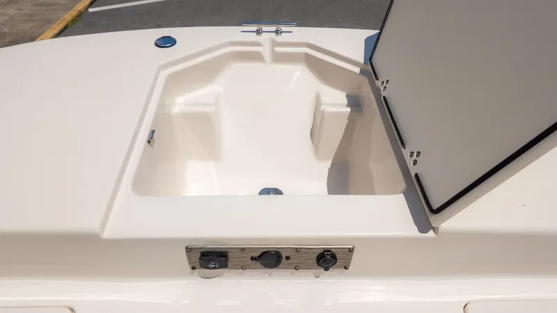 Slide: The Image of Front storage compartment of a Carolina Skiff 17 LS boat, open, with control elements below. - 14