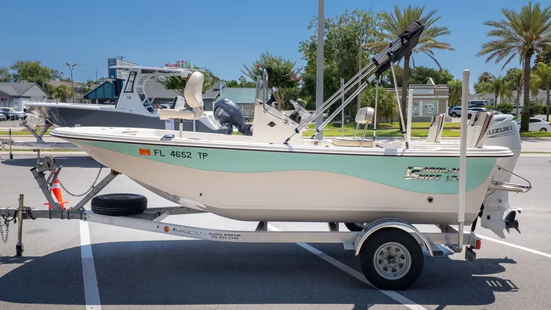 Slide: The Image of A Carolina Skiff 17 LS boat on a trailer, parked in a lot under sunny weather. - 23