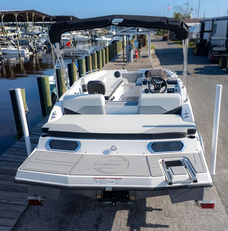 Slide: The Image of The image shows a modern motorboat docked at a pier. It features an open deck and a black canopy. - 5