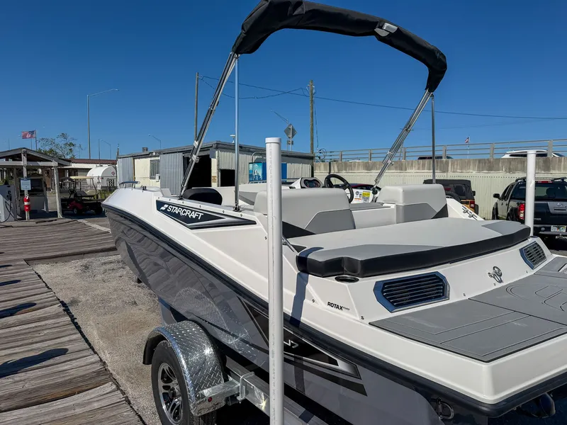 Slide: The Image of A 2027 Starcraft J7 JET Standard boat on a trailer in a harbor area. - 4