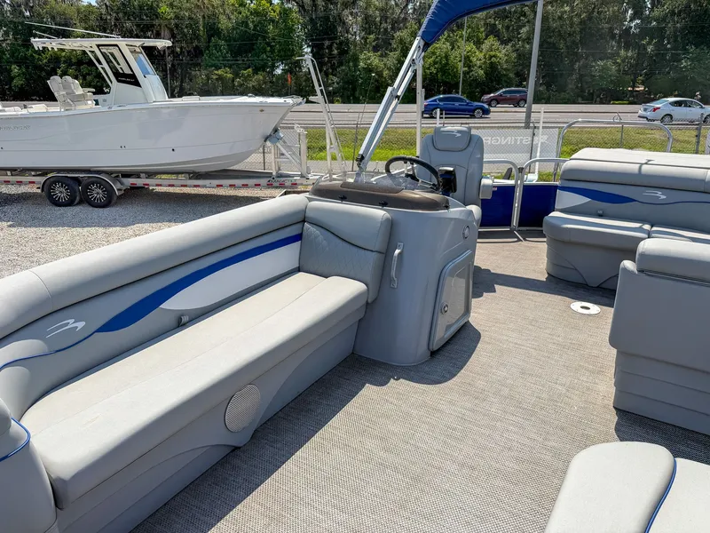 Slide: The Image of The image shows the interior of a Bennington 20 SVL pontoon boat with gray and blue seating. - 6