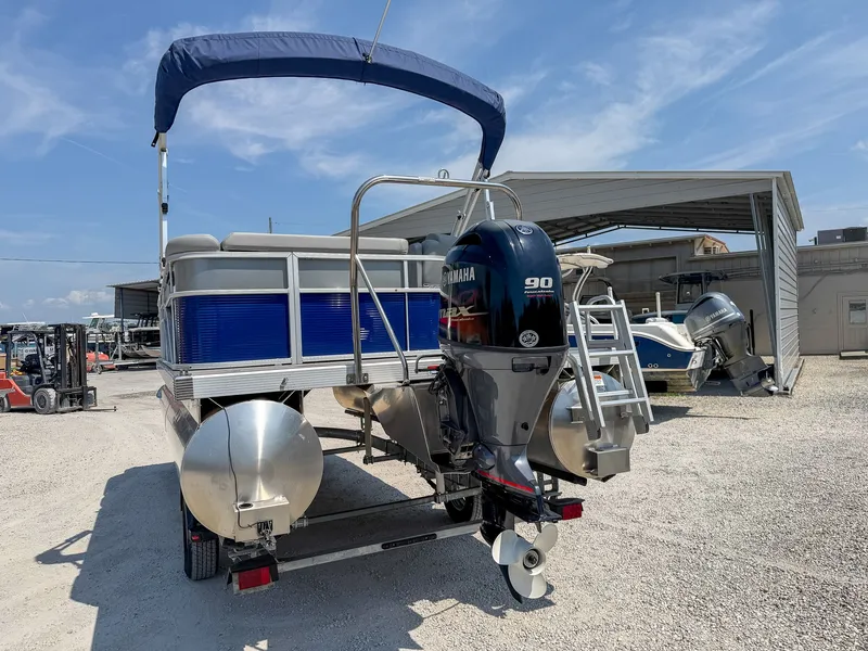 Slide: The Image of A 2024 Bennington 20 SVL pontoon boat with a blue canopy and Yamaha 90 HP outboard motor. - 4