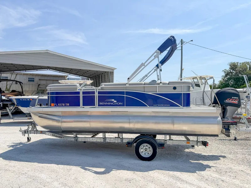 Slide: The Image of A 2024 Bennington 20 SVL pontoon boat on a trailer in an outdoor storage area. - 12