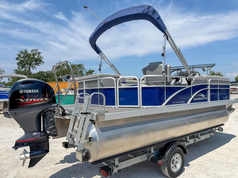 Slide: The Image of A 2024 Bennington 20 SVL pontoon boat with a Yamaha outboard motor on a trailer. - 3