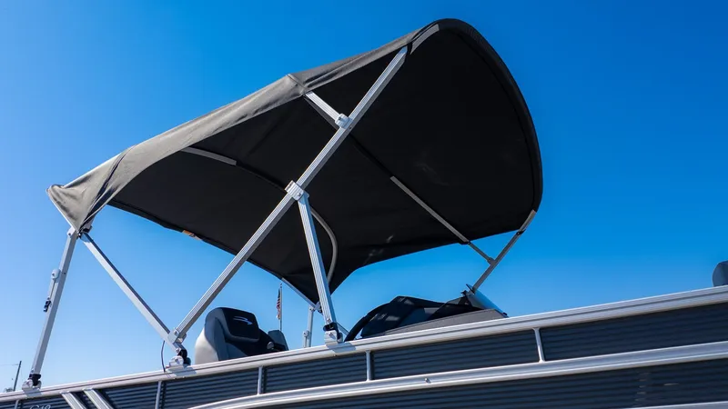The Image of A Bennington 18 S Fish and Cruise boat with a black canopy under a clear sky. - 1