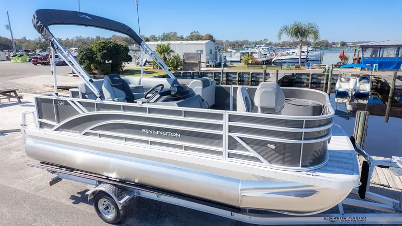 Slide: The Image of A Bennington 18 S Fish and Cruise pontoon boat on a trailer, ready for the water. - 17