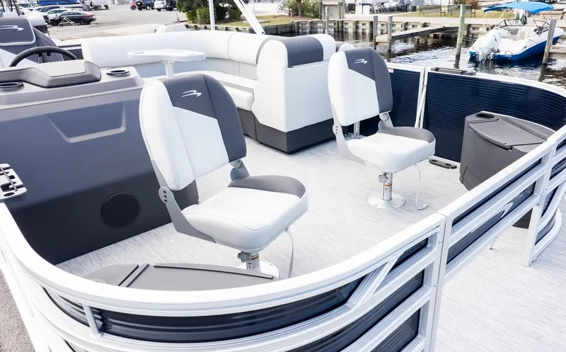 Slide: The Image of The image shows a modern pontoon boat with gray and white seating, docked at a marina. - 13