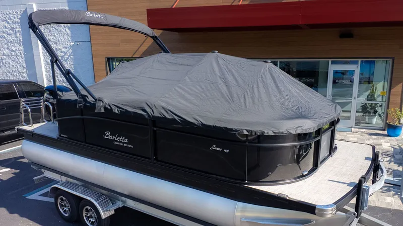 The Image of A 2026 Barletta Sanza 20L pontoon boat with a cover on a trailer. - 1